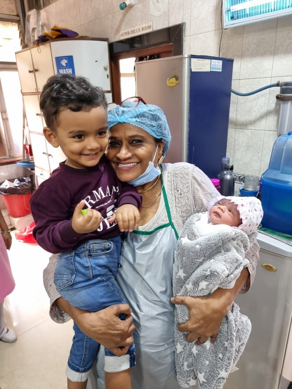 Dr. Fehmida Shaikh cradling newborn baby with family